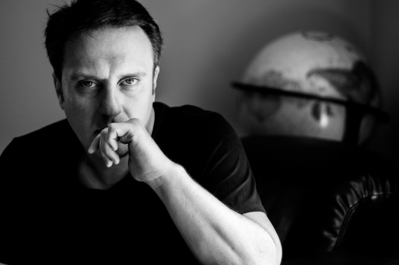 Black-and-white portrait of Jason Webb, hand at his chin