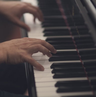 Hands playing piano keys