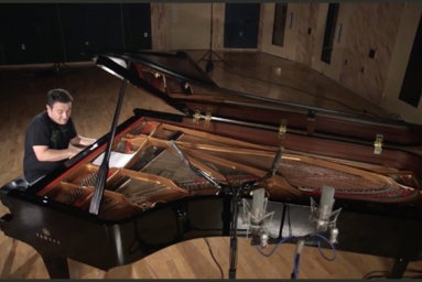 Jason Webb playing a Yamaha grand piano in a recording studio