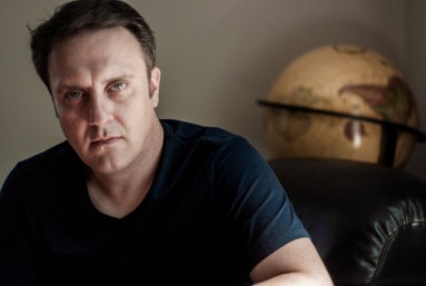 Portrait of Jason Webb beside a globe
